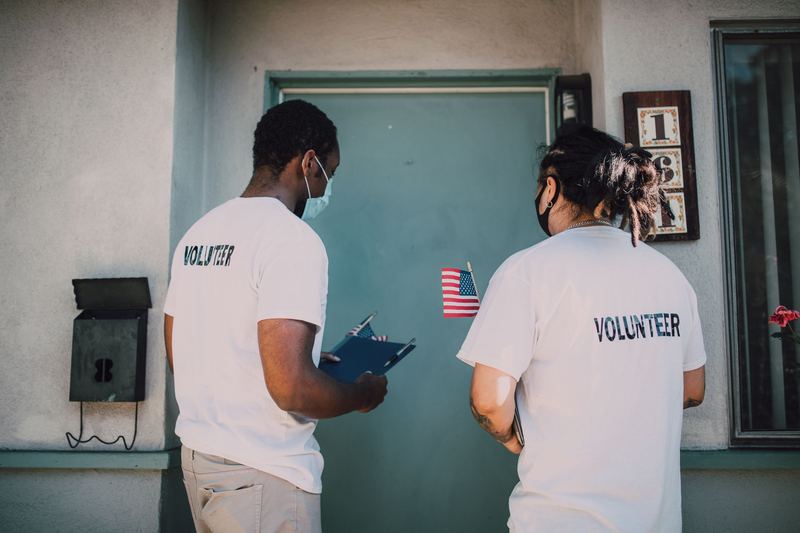 Two volunteers with a clipboard at a front door