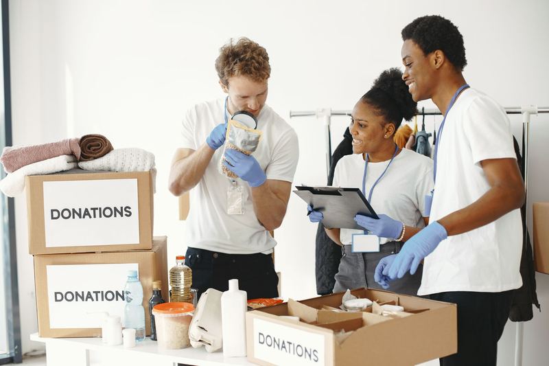 A coalition team reviewing a tablet together beside donation boxes