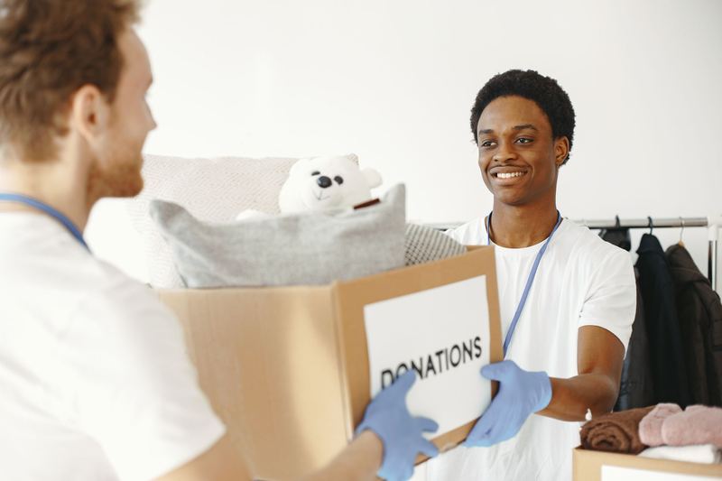 A volunteer handing over a box of donations